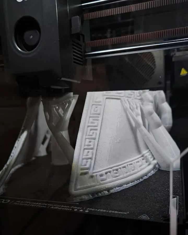Impresora 3D de filamento imprimiendo una pieza blanca
